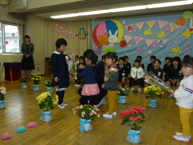 2歳児がお花を渡しているところ