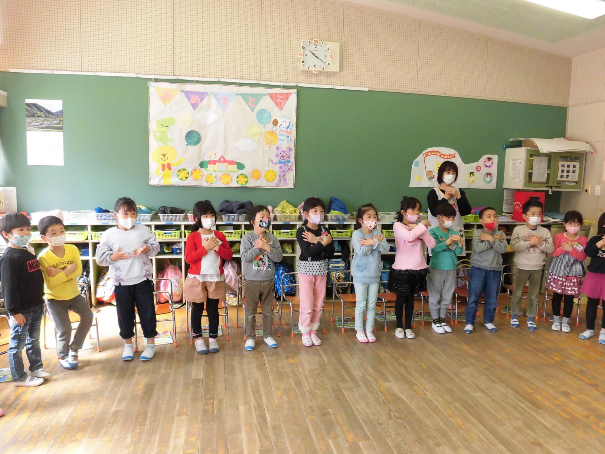かわいい振り付けで「アイラブユー！みんな大好き！」と歌っている写真。