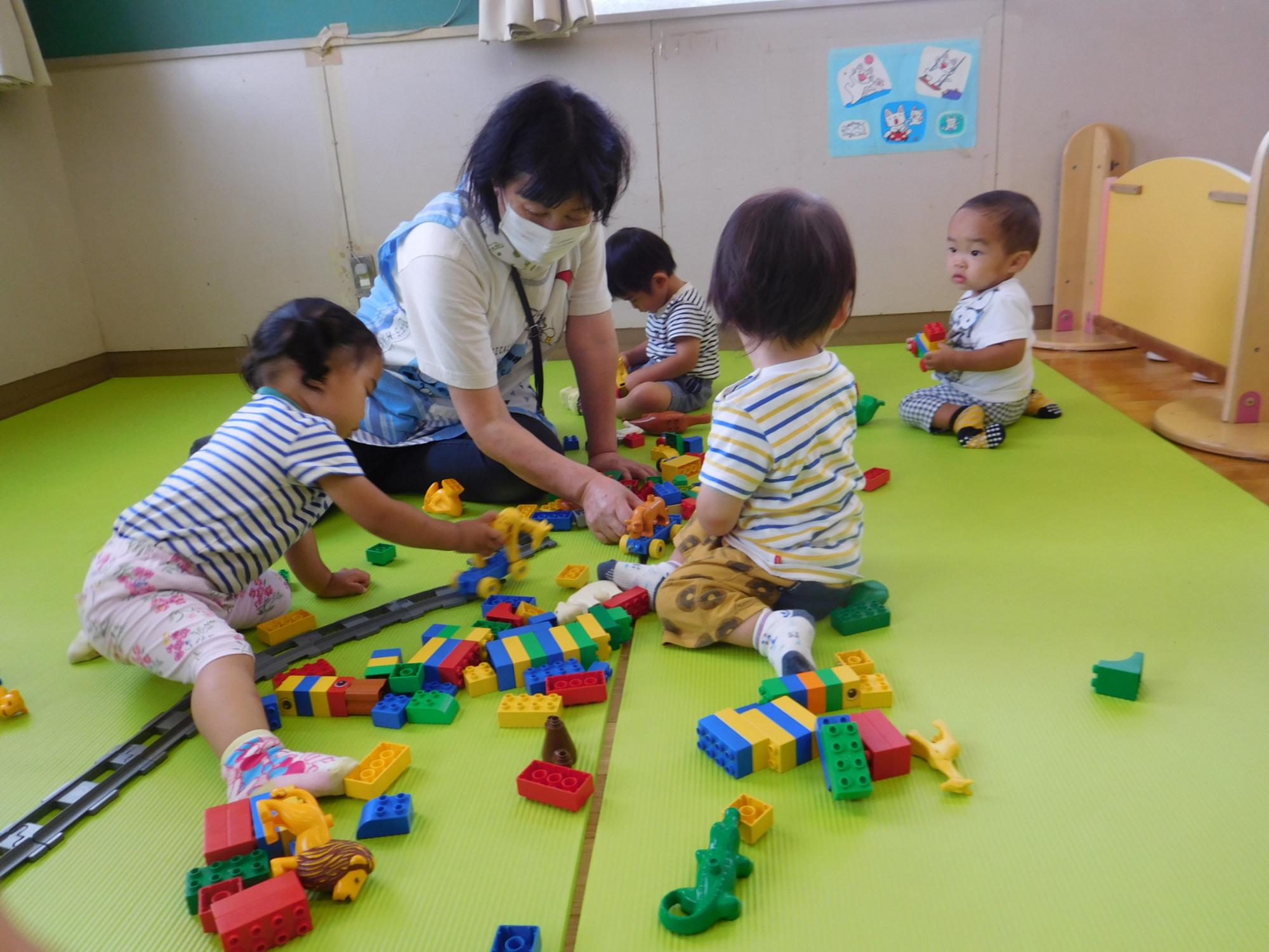 室内で子どもと保育者がブロックをしているところ