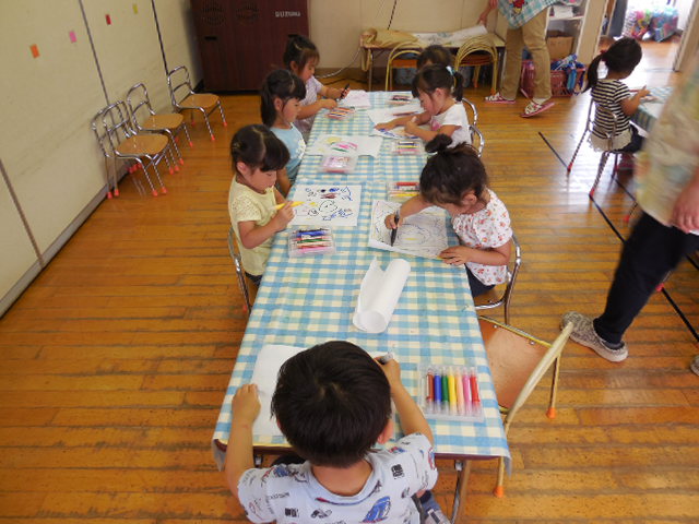 障子紙に絵を描いて水でっぽうの的を作っているところ。