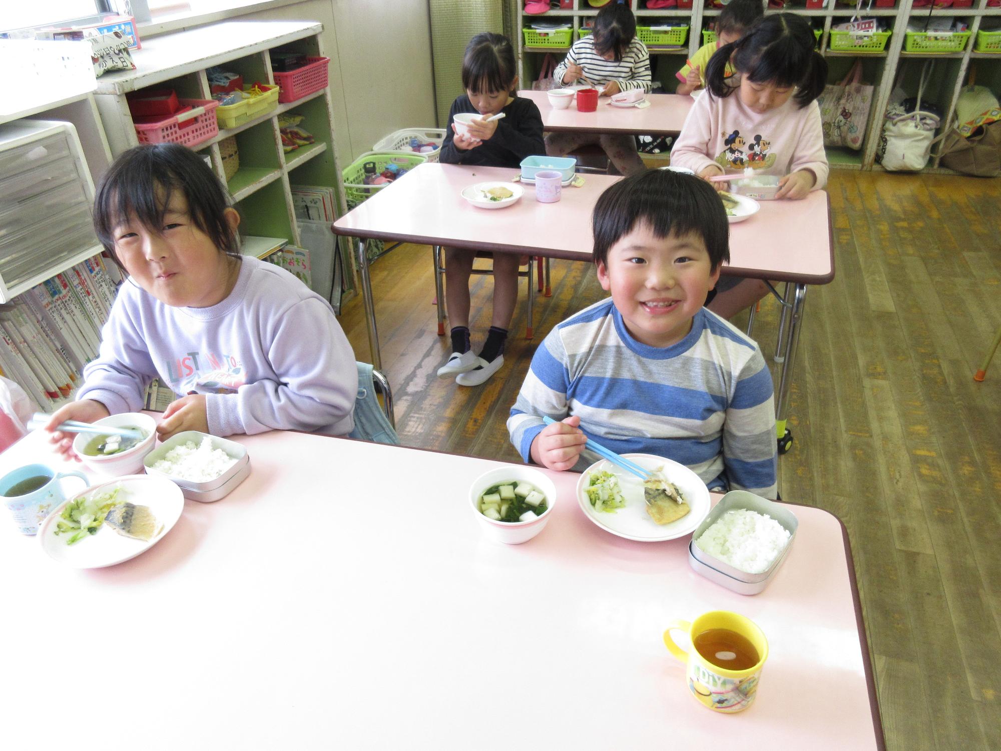 5歳児が笑顔で食事をしているところ