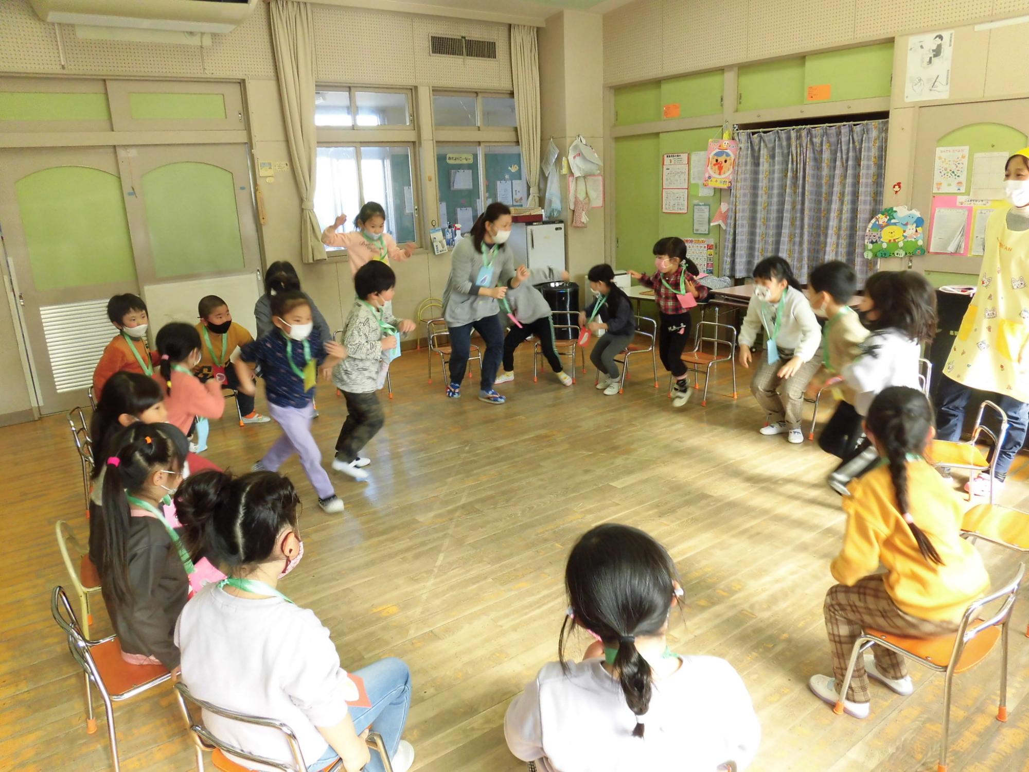 5歳児が食べ物バスケットのゲームを楽しく行っている。