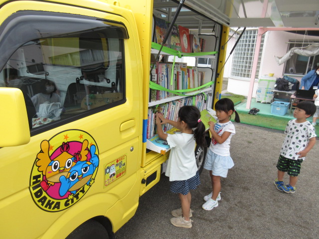 移動図書館の車の本を子どもたちが選んでいる。