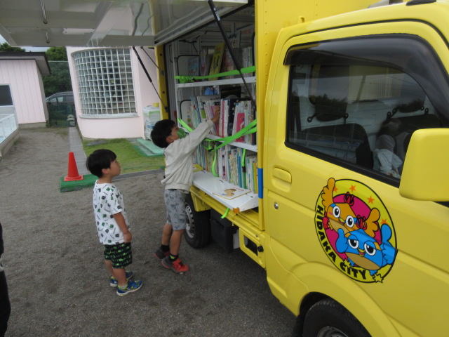 移動図書館の車の本を子どもたちが選んでいる。