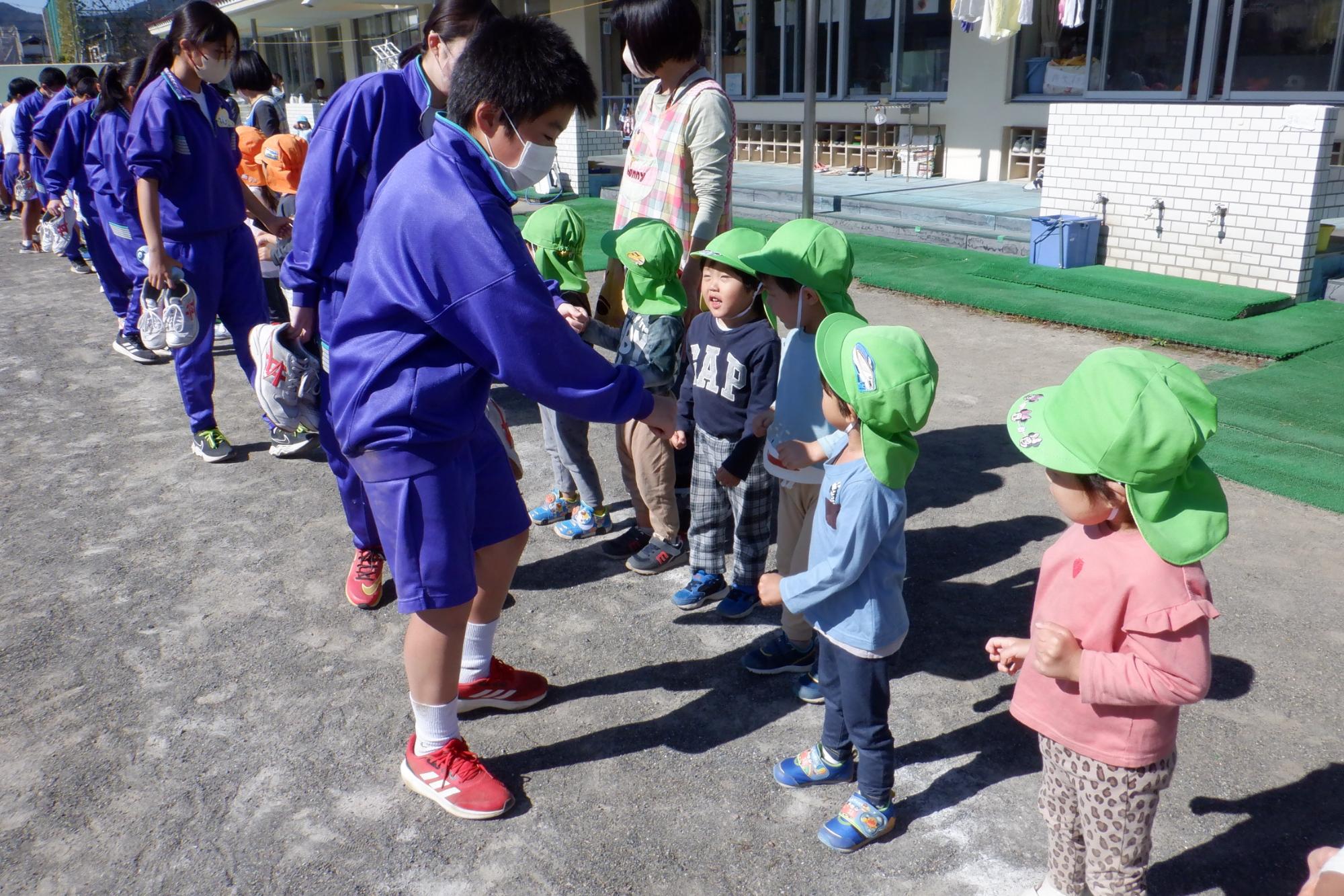 中学生を見送る子ども達