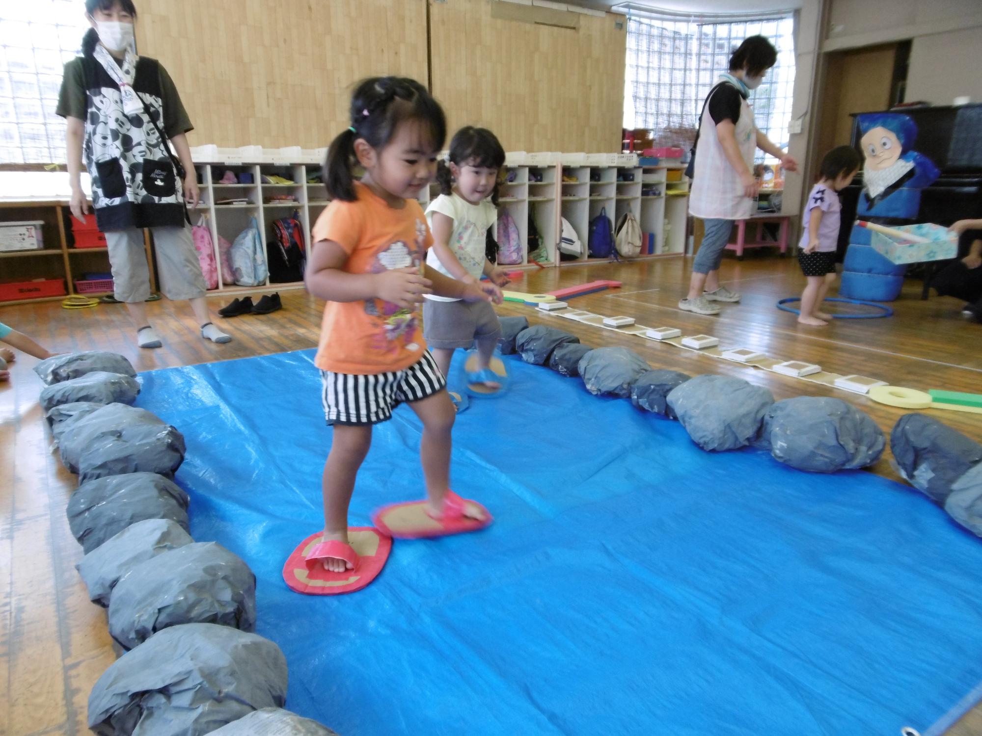 二歳児が草履をはいて池渡りの忍者修行をしている写真