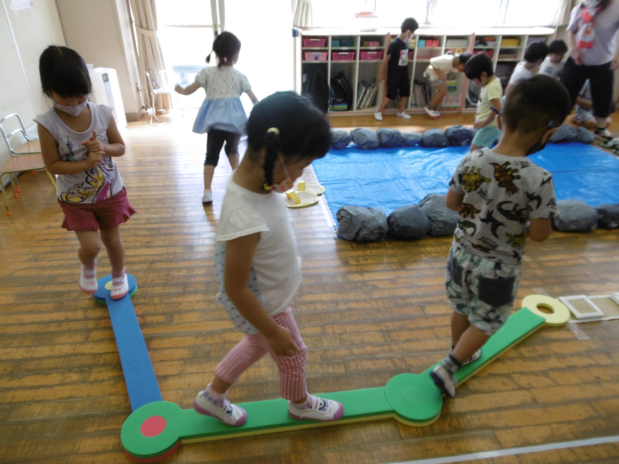 子どもたちが平均台を渡っている写真