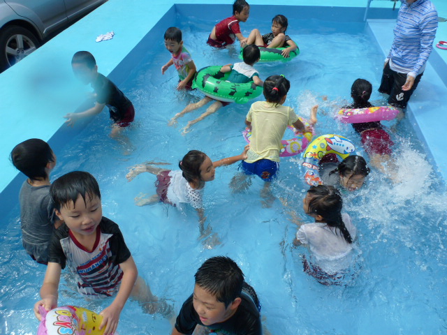 子どもたちがプールでのびのびと遊んでいる写真です