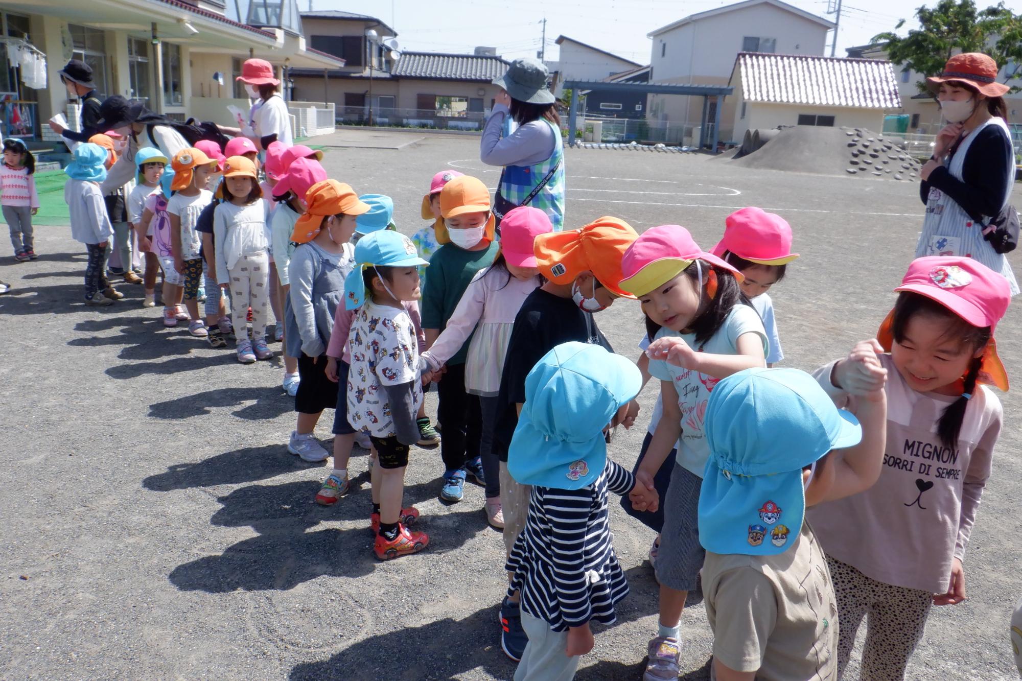 手をつないで散歩に出かける子どもたち