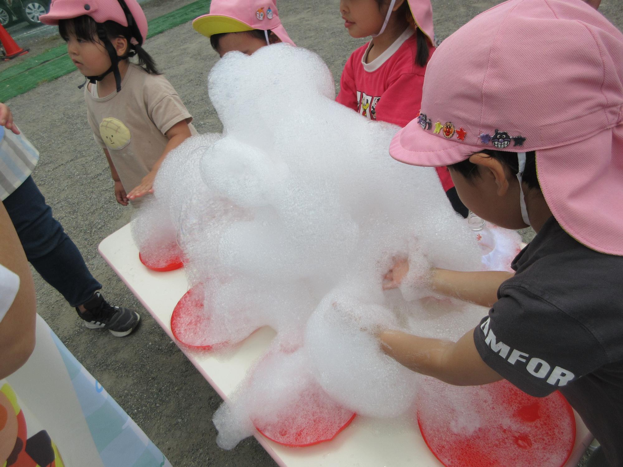 しゃぼん玉の泡を触って楽しんでいる様子