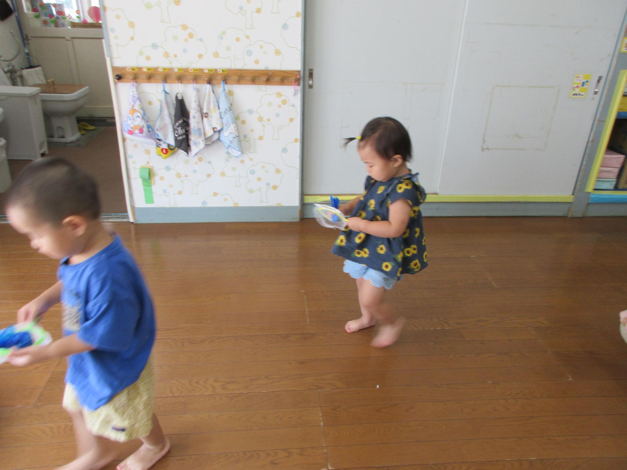 すくった金魚に見立てたおもちゃを落とさないように運んでいるところ