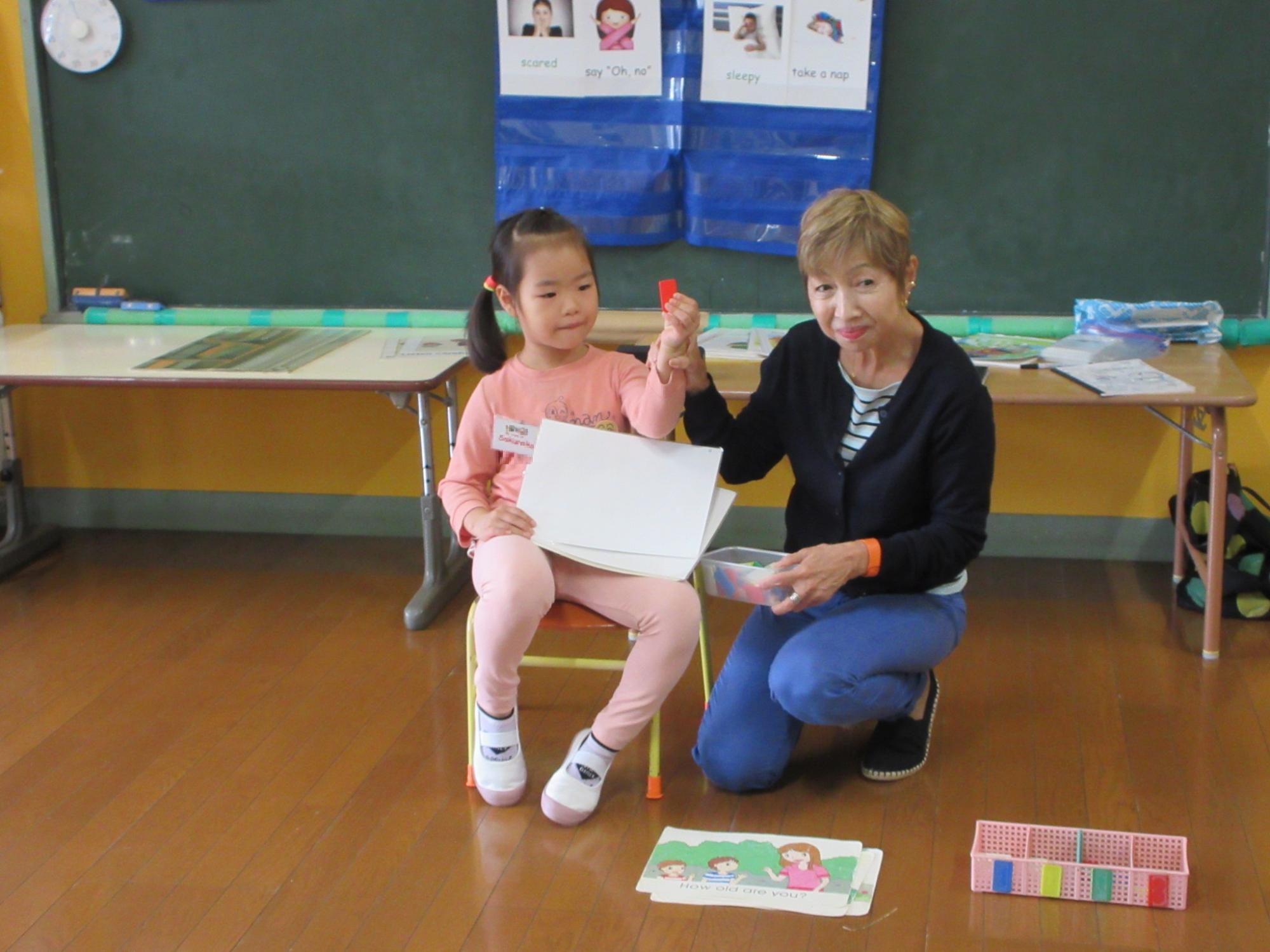 子どもが前に出て先生のお手伝いをしている写真