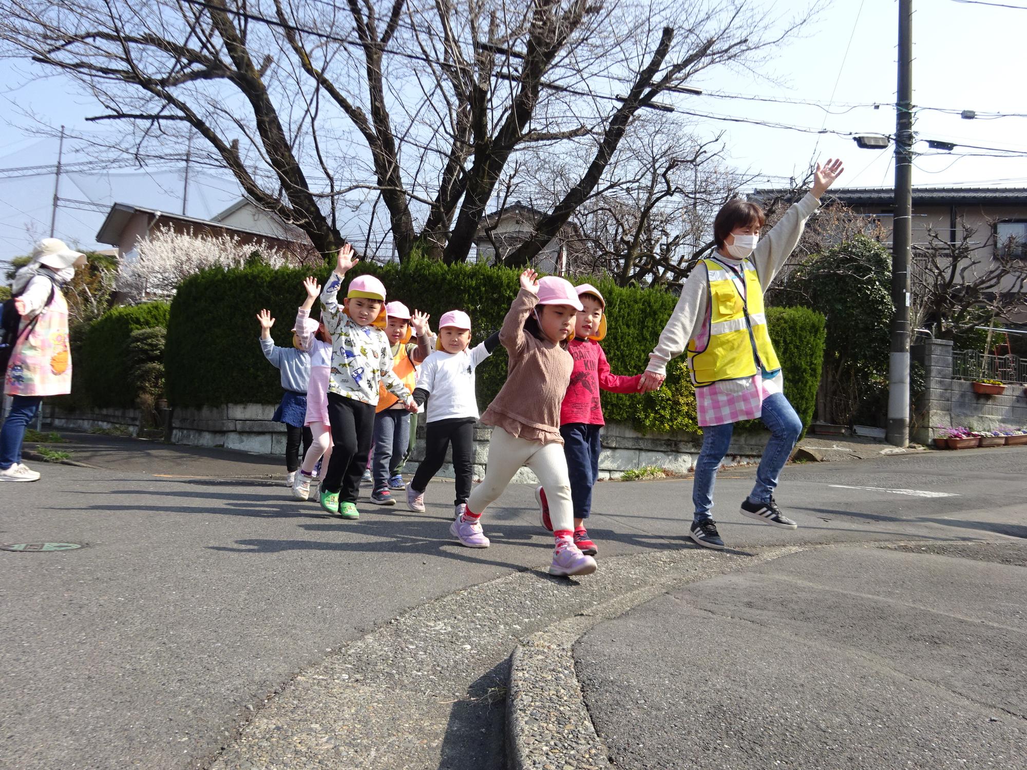 道路を手を挙げて横断中の4歳