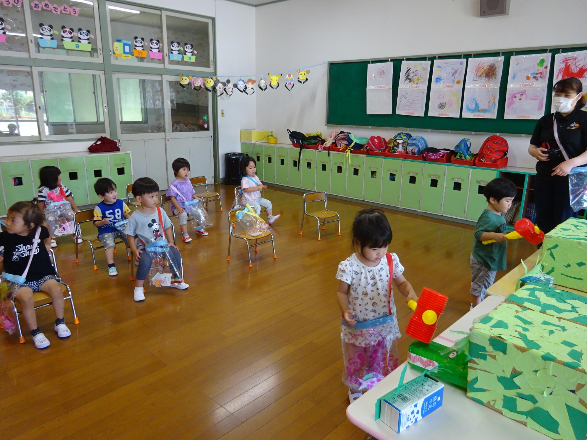 ワニワニパニックゲーム。ワニがいつ出てくるかドキドキする2歳児と、自分の番が来るのを楽しみに待つ子供たち。