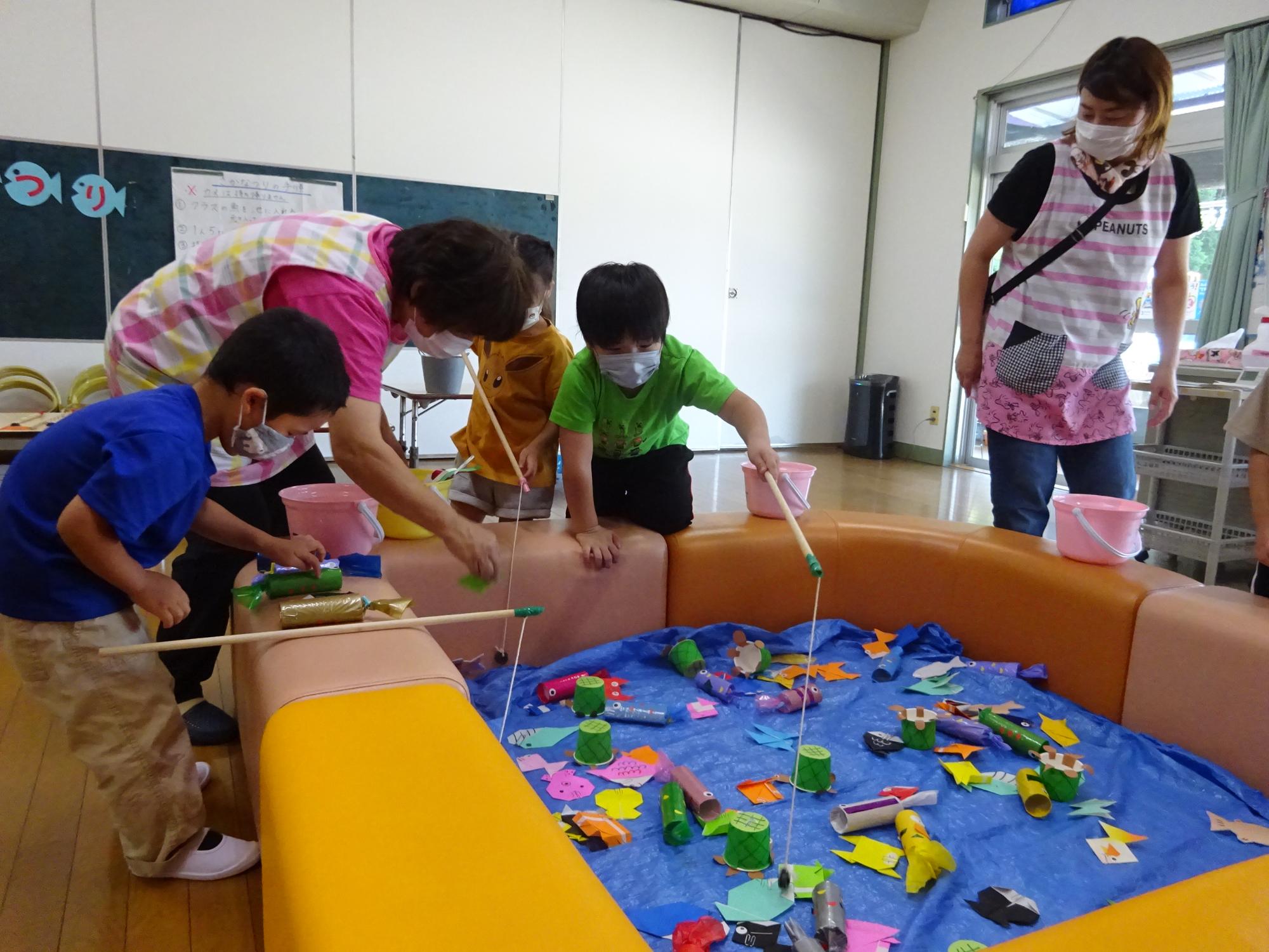 魚つりコーナー。狙った魚を釣ろうと身を乗り出す4歳児。