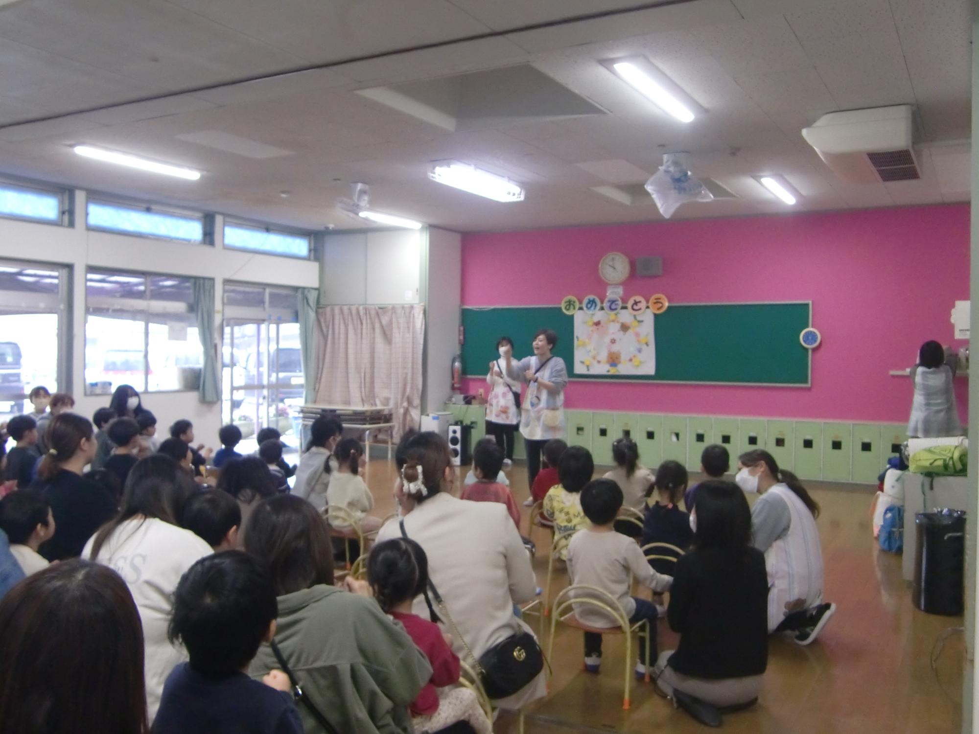 保護者、子どもたちと手遊び「トントンひげじいさん」をしているところ