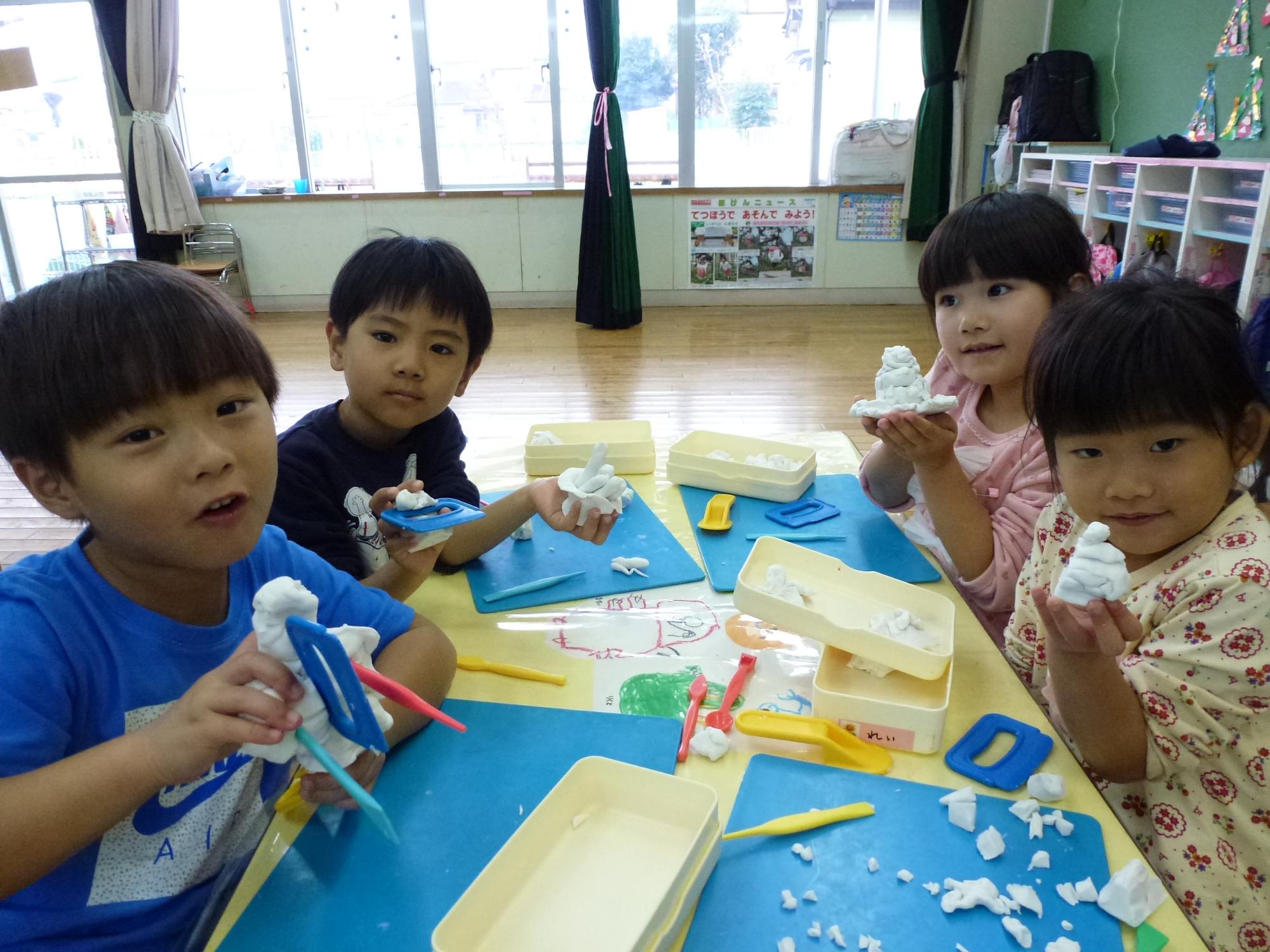 粘土の作品を見せる子ども達