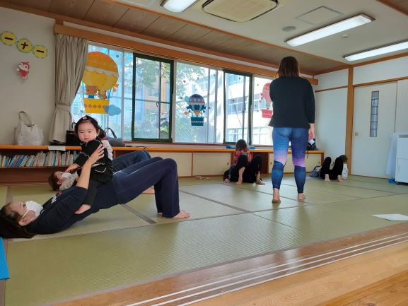 子どもをお腹の上にのせてポーズをとる参加者の皆さん