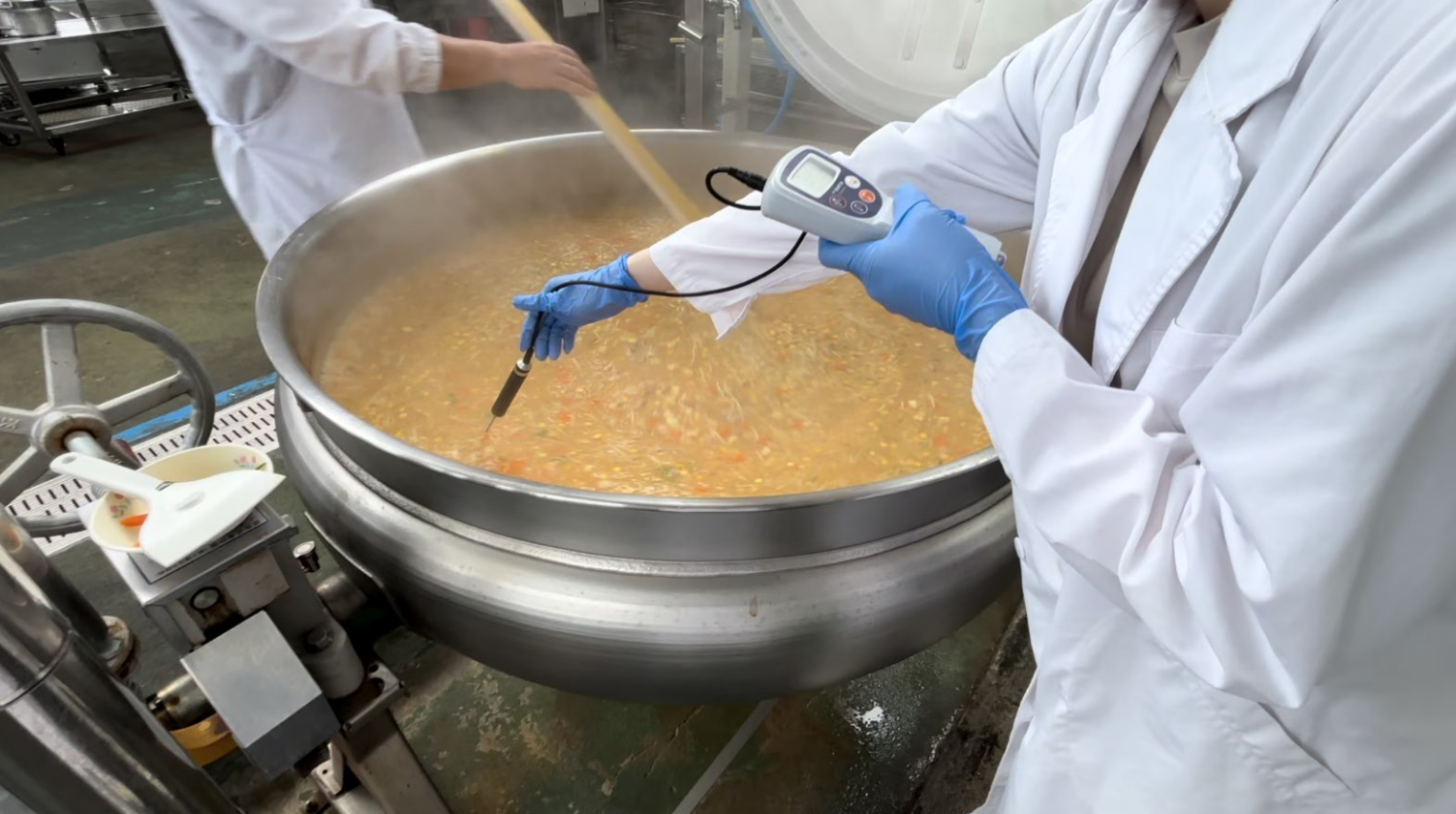 大きな釜で調理をしている写真