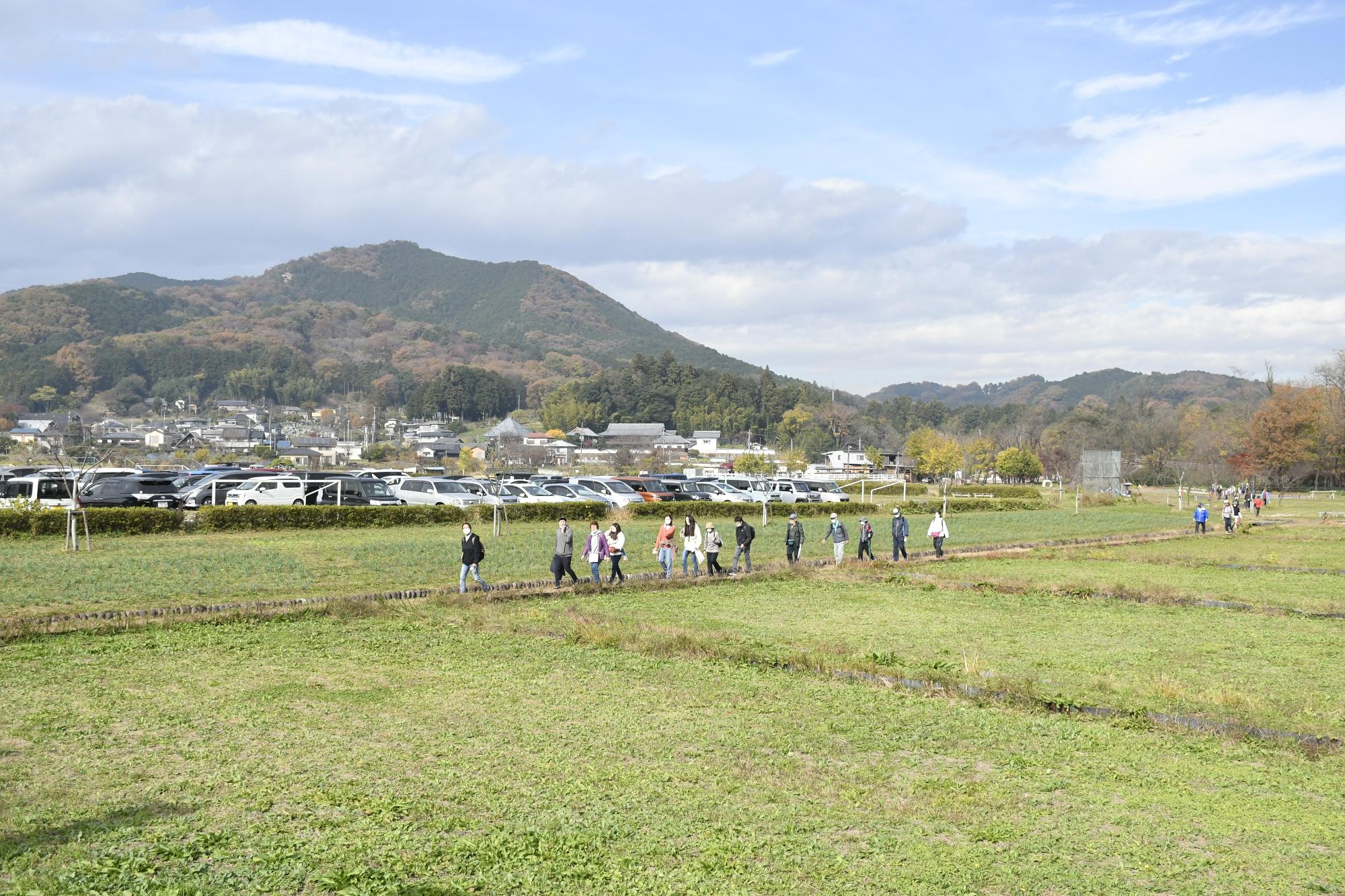 日和田山を背景に歩くウオーカー