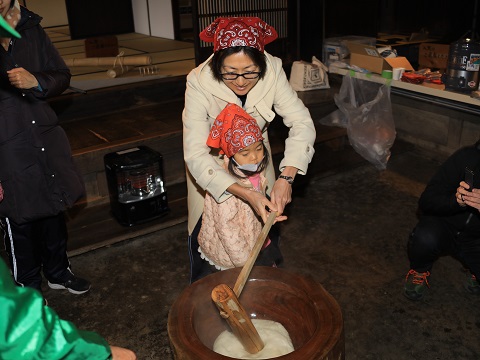 親子で餅つきしている写真