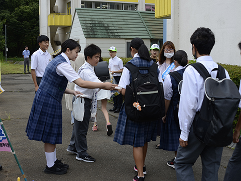 武蔵台小中学校でポケットティッシュなどの啓発品を配る生徒の様子