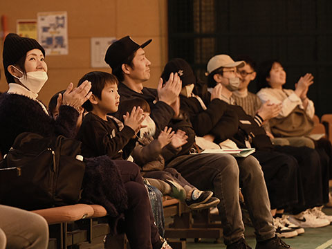 演奏を聞き拍手している親子