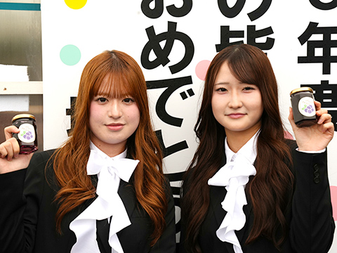 学生2人が日高市の特産品であるブルーベリージャムを持ちながら記念撮影