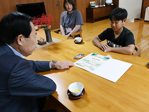 今回出場した大会のメダルと賞状を見る市長