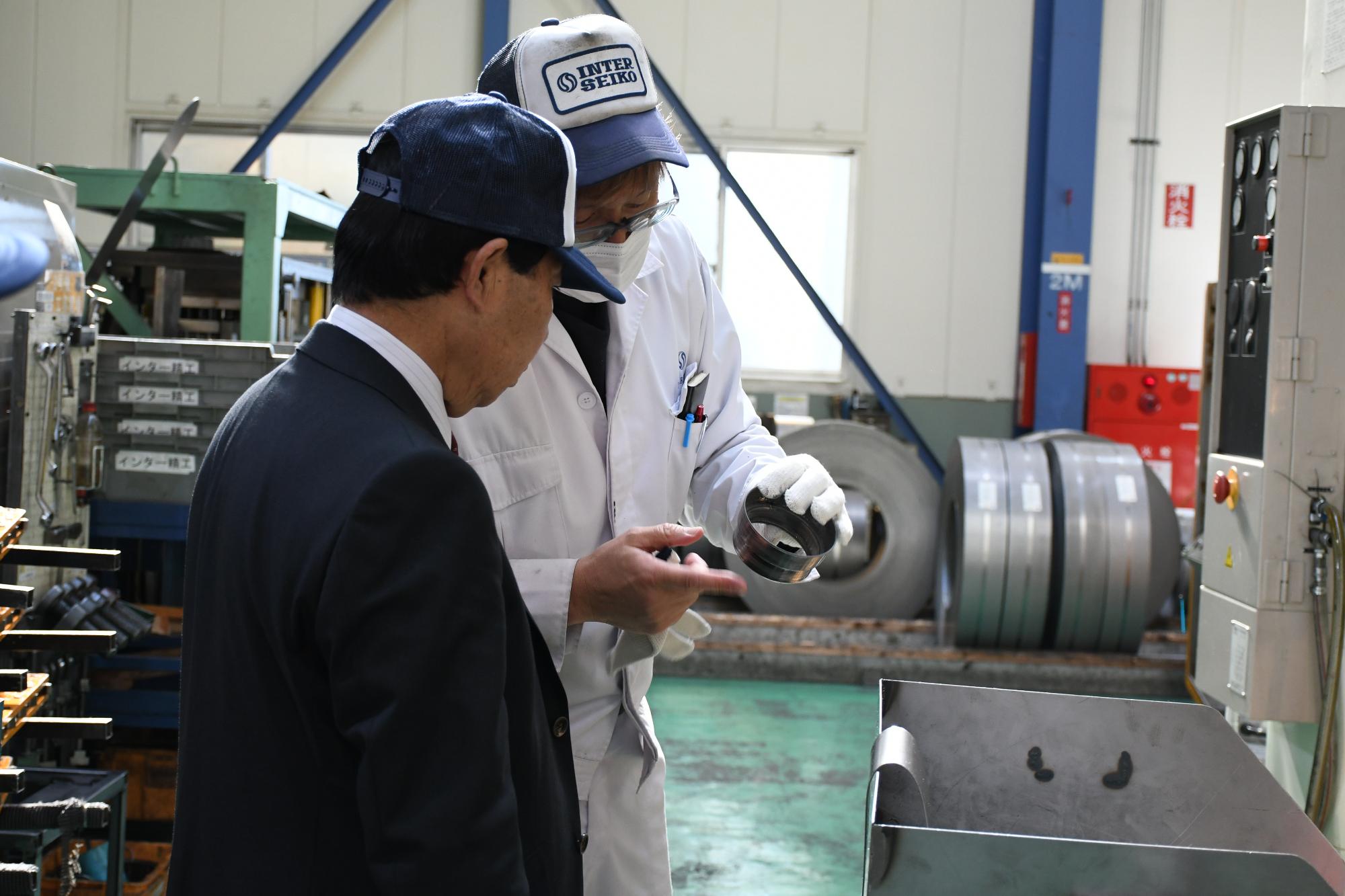 製造された部品を見る市長