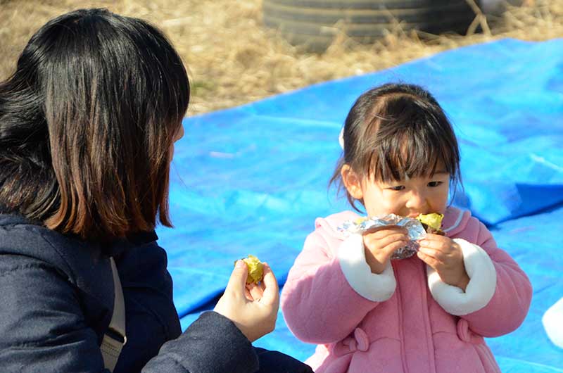 親子で焼き芋を食べている様子