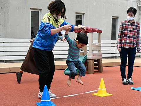 障がい物のロープをジャンプで飛び越えている男の子