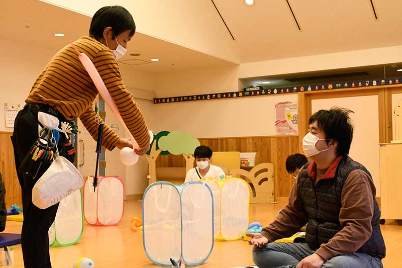 お父さんがバルーンアートを教わっている様子