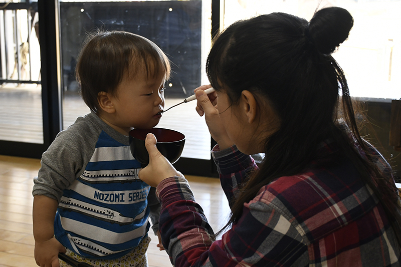 出来上がったおしるこを子どもに食べさせてあげている様子