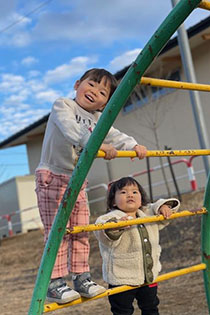 子ども2人が遊具で遊んでいる写真