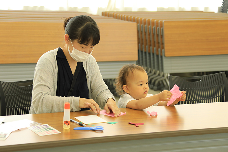 紙を折ったりしながらメッセージカードを作る親子の様子