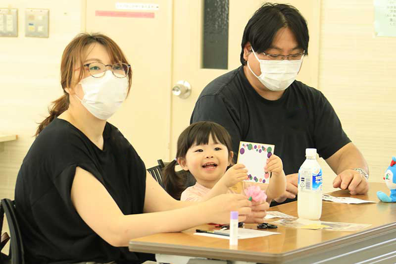 母、父、娘の3人でメッセージカードを作る様子