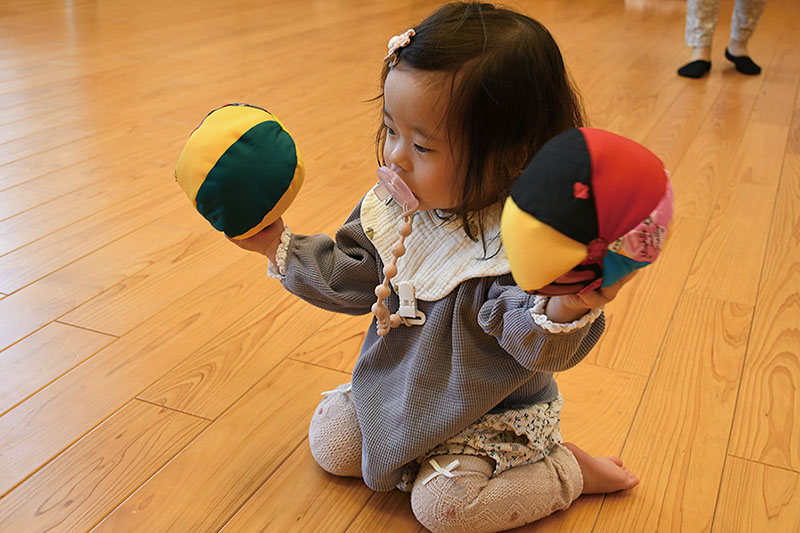 右手左手それぞれにボールを持ち上げ、興味津々