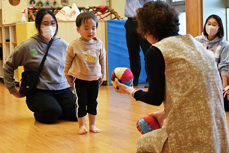 先生がボールを使い子どもを誘導中