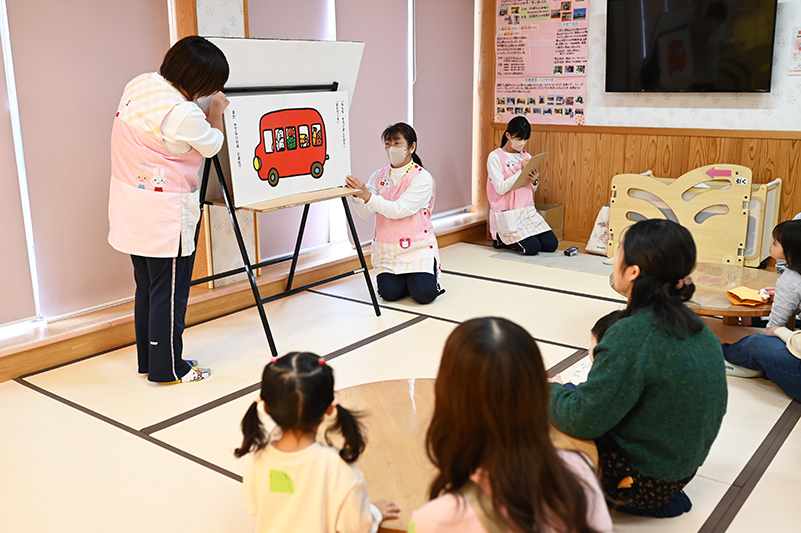 お話を聞いているママと子ども