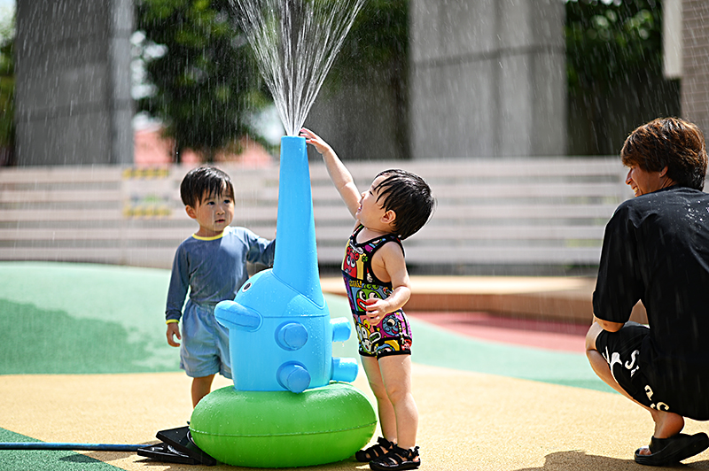 ゾウさんの噴水から水が出でて、遊んでいる子どもたち