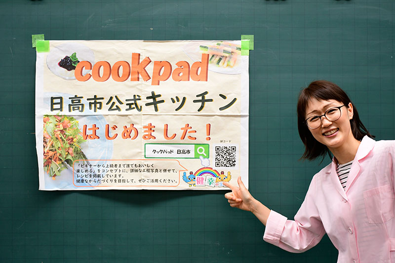 「クックパッド日高市公式キッチン始めました」と書かれたポスターを指す前澤有紀さん
