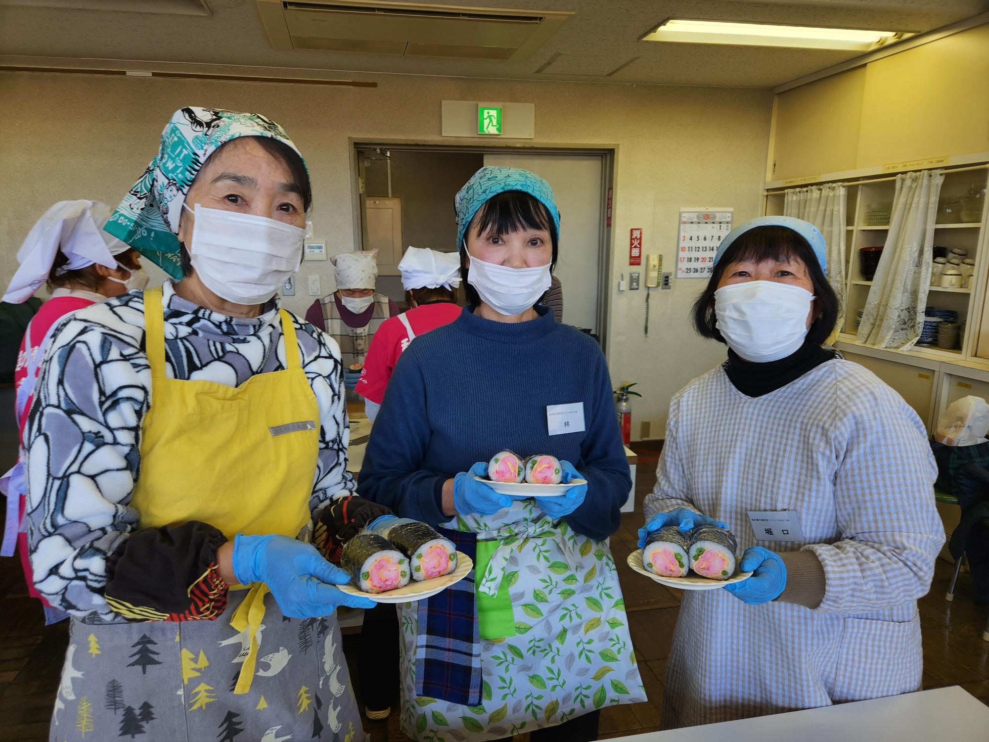 花の巻きずしを手にする参加者3人の写真