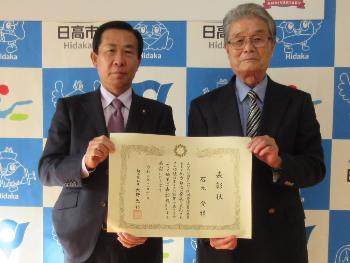 県知事表彰を受けた石元登さん（右）と市長（左）の記念写真