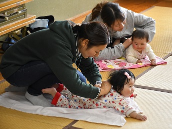 赤ちゃんの背中をさするママたち