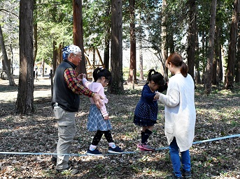 ふらふら動くゴムの上を歩く大人と子ども