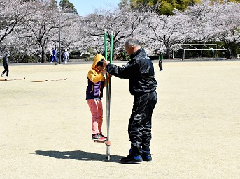 竹馬をする男の子と支える男性