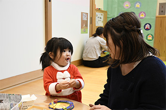 クリスマスのリースを作成している親子の様子
