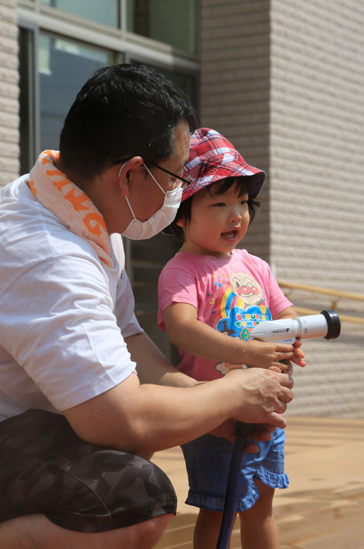 シャワーを持つ子どもの写真