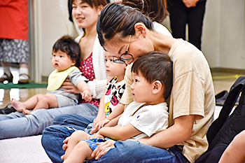 ママにだっこされてじっとお話を聞く子ども